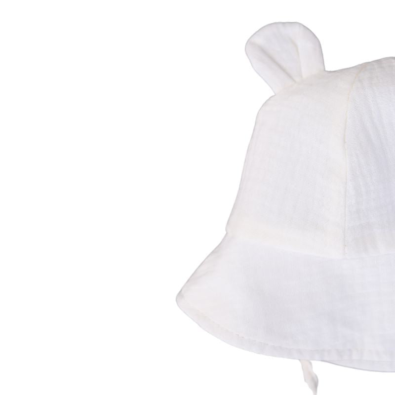 Kreminė vaikiška kepuraitė su ausytėmis ir raišteliais Kreminė 100% medvilnės vaikiška kepuraitė